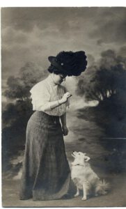 Ein Frau übt spielerisch mit ihrem Spitz Kunststückchen ein